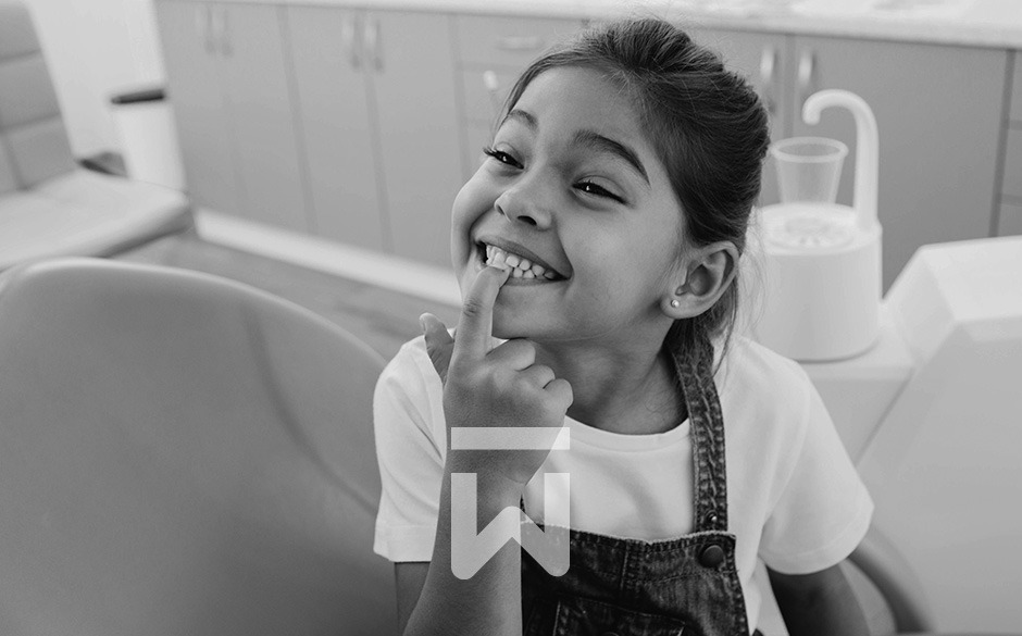 Ein grinsendes Mädchen zeigt Zahnärztin Olowookere stolz ihre Zähne
